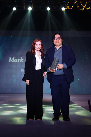 Award-winning director Mark Meily receives trophy from French cinema icon Isabelle Huppert.